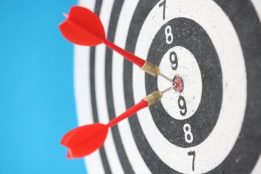 İki kırmızı dart hedefi vuruyor mavi arkaplanda yakın plan