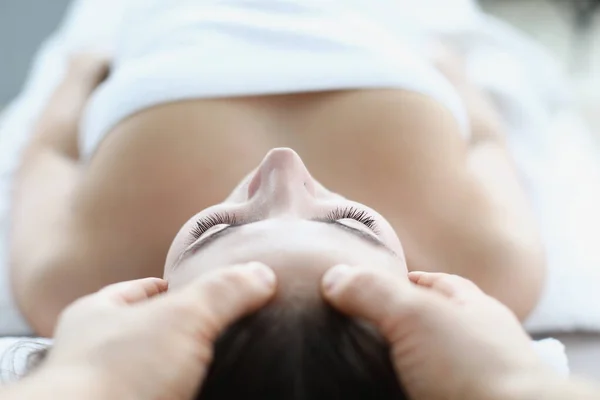 Jonge vrouw masseur maakt gezicht en hoofd massage in spa salon — Stockfoto