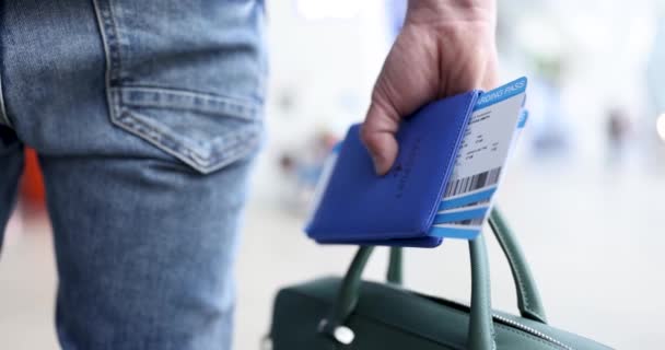 Hombre caminando por el aeropuerto con bolsa y pasaporte con entradas película 4k — Vídeos de Stock