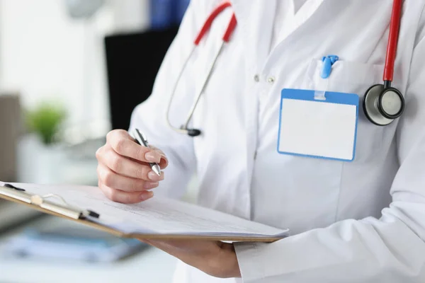 Medico donna che tiene appunti con documenti e penna a sfera in mano primo piano — Foto Stock
