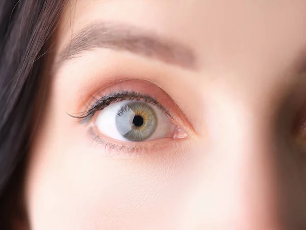 Frau mit weit geöffnetem Auge und grau-grüner Pupille-Nahaufnahme — Stockfoto