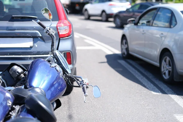 Moto bleue couchée devant la voiture sur le gros plan de la route — Photo