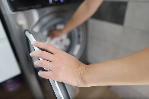 Жінка бере чисту білизну з пральної машини крупним планом — стокове фото