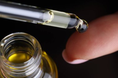 Makyaj şişesi tutan kadın, nemlendirici serum ya da...