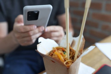 Adam akıllı telefondan öğle yemeği siparişi veriyordu.