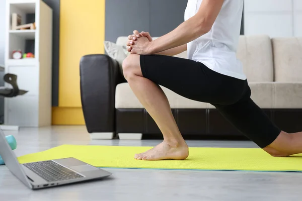 Jovem realiza exercícios esportivos para esticar os músculos da perna — Fotografia de Stock