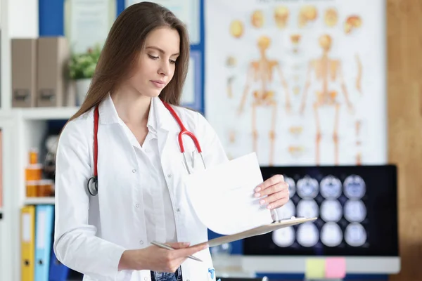 Femme médecin tenant presse-papiers avec des antécédents de patient à la clinique — Photo