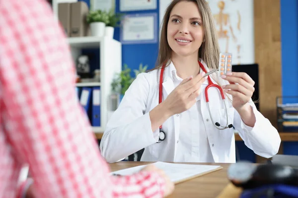 Doctor gynecologist showing woman patient blister with pills in clinic — Stockfoto