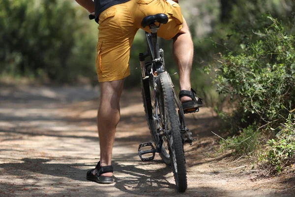 Mann in kurzen Hosen sitzt auf Fahrrad im Park — Stockfoto
