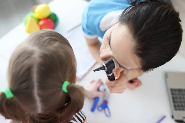 Otolaryngologist melihat telinga gadis kecil dengan penutup otoskop — Stok Foto