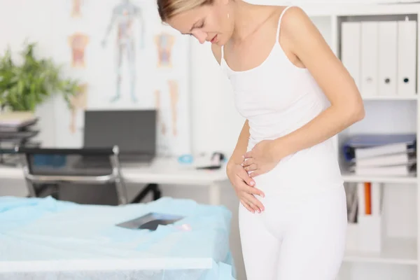 Young woman with abdominal pain in medical office — Stock Photo, Image