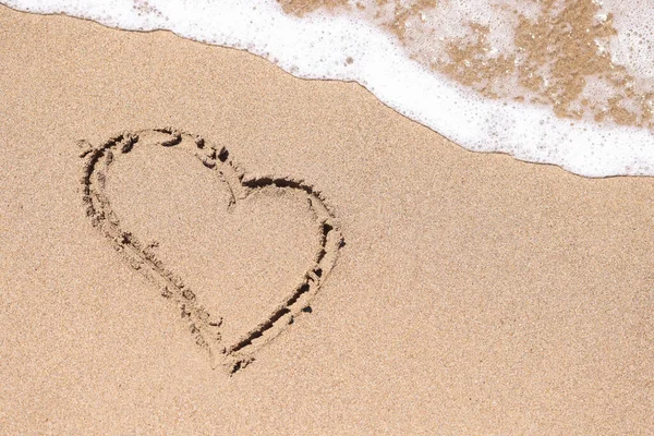 Мальоване серце на мокрій піску поруч з морем крупним планом — стокове фото
