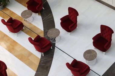 Kırmızı sandalyeler ve küçük masalar büyük salonun üst manzarasında duruyor.