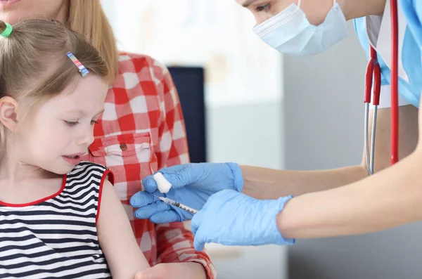 Lekarz pediatra szczepi małą dziewczynkę w ramię — Zdjęcie stockowe