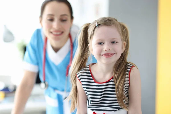 Retrato de niña feliz posando mientras mira la cámara después de una buena consulta con el pediatra —  Fotos de Stock