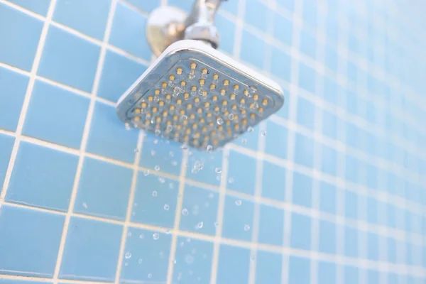 Ducha de pared cromada sobre azulejos azules con gotas de agua — Foto de Stock