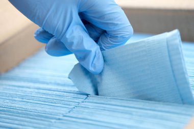 Eldivenli doktor tek kullanımlık peçeteleri çıkartıyor.