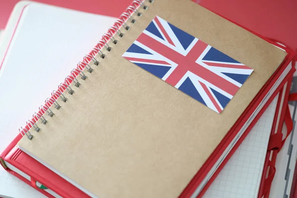 Stylish notepad with britain flag and copybooks on table
