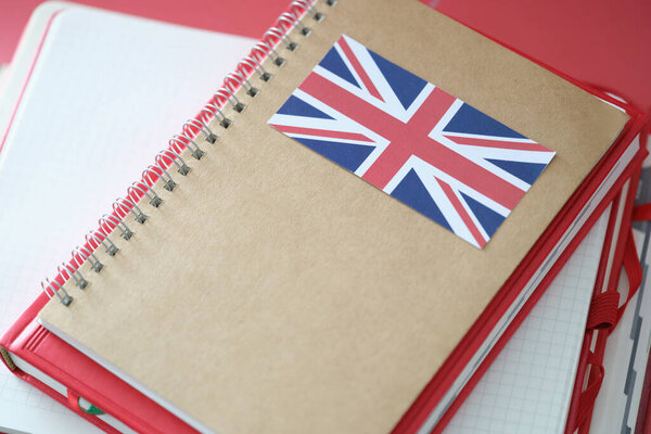 Stylish notepad with britain flag and copybooks on table