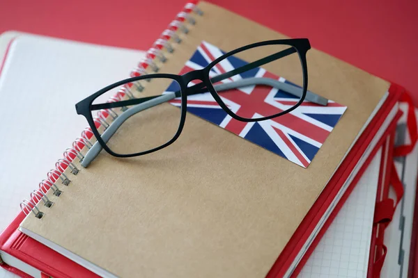 Podręcznik języka brytyjskiego i okulary są na stole — Zdjęcie stockowe