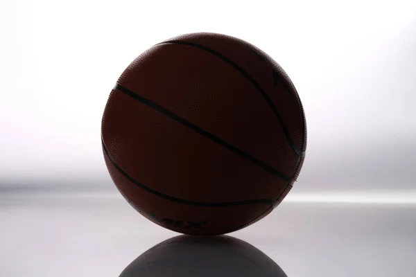 Barna bőr kosárlabda labda fekszik fehér háttér — Stock Fotó