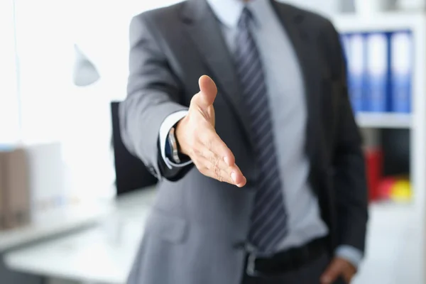 Mann im Business-Anzug streckt die Hand zum Händedruck aus — Stockfoto