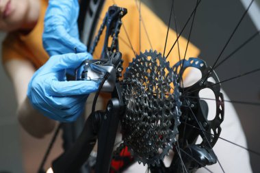 Lastik koruyucu eldivenli bir zanaatkar bisiklet tamiri yapıyor.