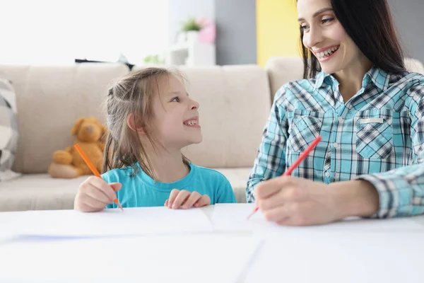 Glad mamma och dotter rita med pennor på papper — Stockfoto