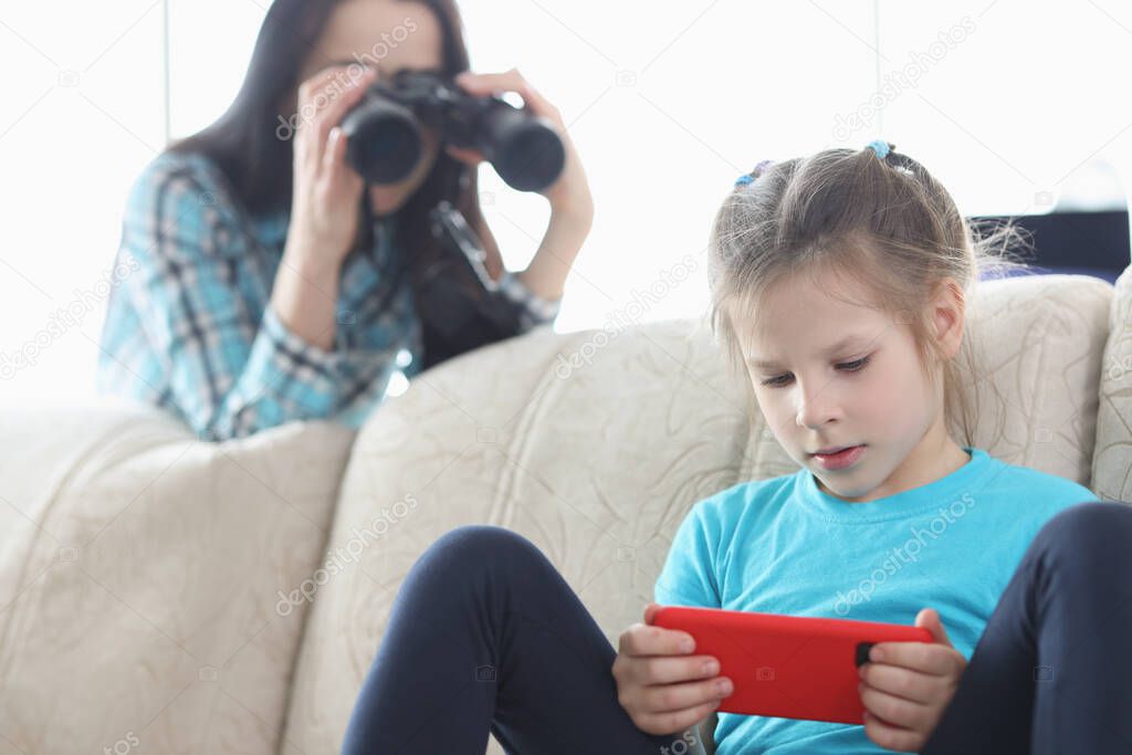 Mom controls her daughter with phone through binoculars