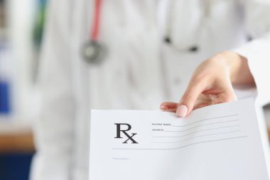 Doktor klinikte boş reçete tutuyor.