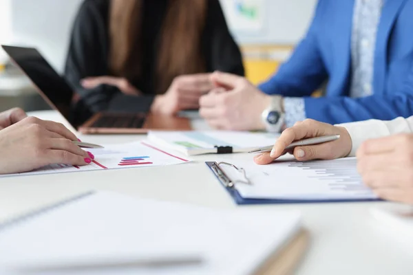 Group of business people are sitting at table with laptop and documents with charts closeup — Stock Photo, Image