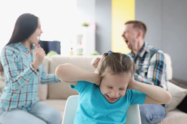 집에서 부모에게 욕을 하는 배경으로 귀를 막고 있는 어린 소녀 — 스톡 사진