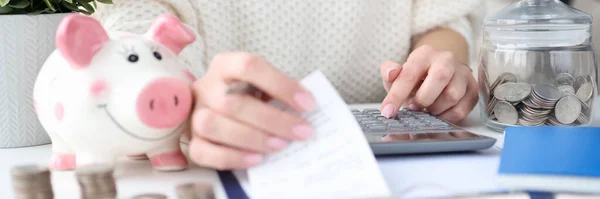 Žena drží šeky pro nákupy v ruce a počítá s detailním záběrem kalkulačky — Stock fotografie