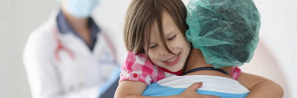 El doctor sostiene a la niña en sus brazos.. —  Fotos de Stock