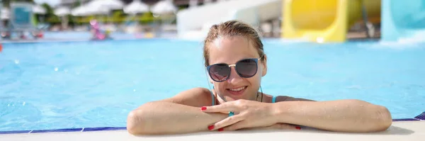 Retrato de mujer en gafas de sol en parque acuático en piscina — Foto de Stock