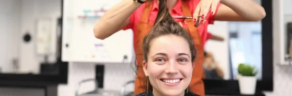 Portrait of smiling woman in hairdressing salon, which master cuts her hair — Stock Photo, Image