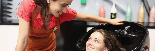 Friseur erklärt Kundin, wie sie ihre Haare richtig wäscht — Stockfoto
