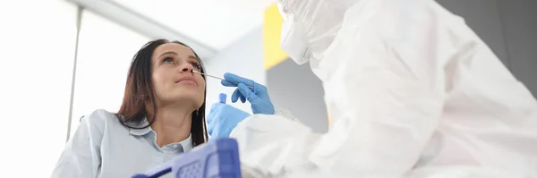 Dokter in beschermend pak is afkomstig van vrouw met wattenstaafje — Stockfoto