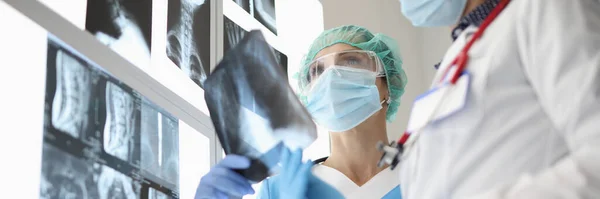 의료용 마스크를 착용하고 있는 의사 2 명이 엑스레이 검사를 받고 있습니다. — 스톡 사진