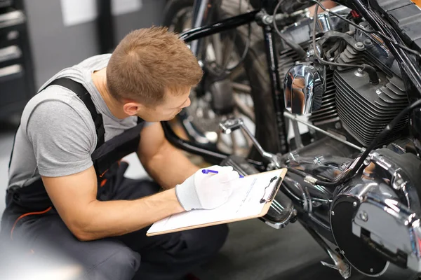 Foreman i service reparationscenter diagnostiserar delar på motorcykel — Stockfoto