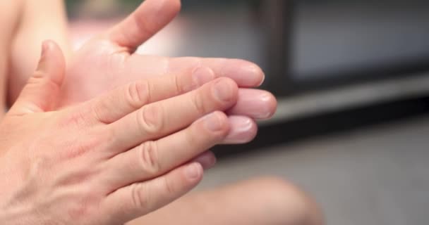 Man applies moisturizing white cream to hands 4k movie — Stok video