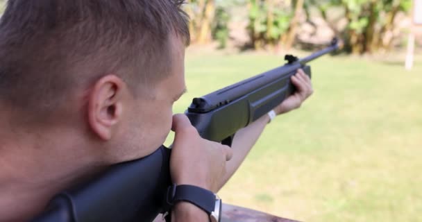 Young man shoots rifle in street shooting range 4k movie — Vídeos de Stock