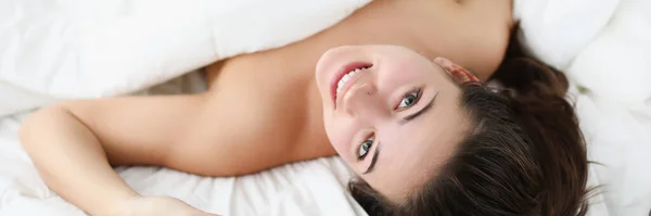 Usmívající se žena leží v posteli. Vstávat brzy ráno v dobré náladě — Stock fotografie