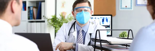 의사는 보호용 마스크를 착용 한 환자를 받는다 — 스톡 사진