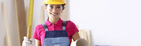 Woman architect holding ruler and paper in workshop — Stock Photo, Image