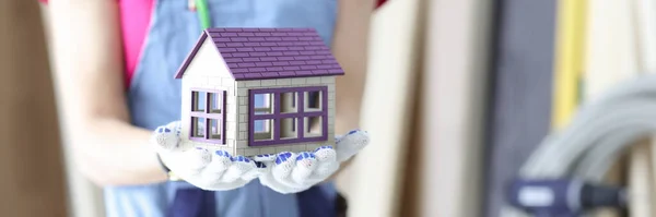 Mulher construtor segurando brinquedo casa de madeira em mãos closeup — Fotografia de Stock