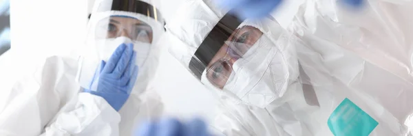 Koruyucu antiveba elbiseli doktorlar hastaya yardım ediyor. — Stok fotoğraf
