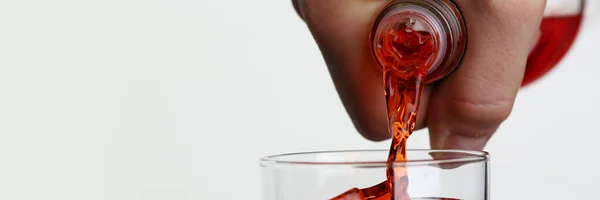 Man pouring orange drink into glass with ice closeup — Stock Photo, Image