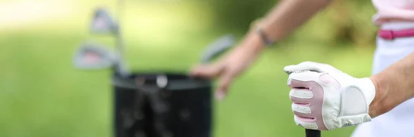 Female hand of golfer in glove holds bag with golf clubs — Stock Photo, Image