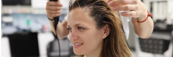 Femme dans un salon de beauté sécher sa tête avec sèche-cheveux — Photo